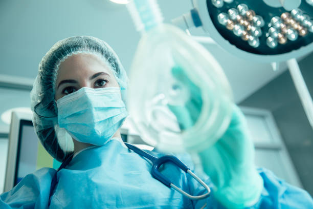 Anestesia hipnótica - Mulher de uniforme médico em pé com uma máscara na mão